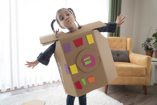 A child dressed in a cardboard box like a robot.